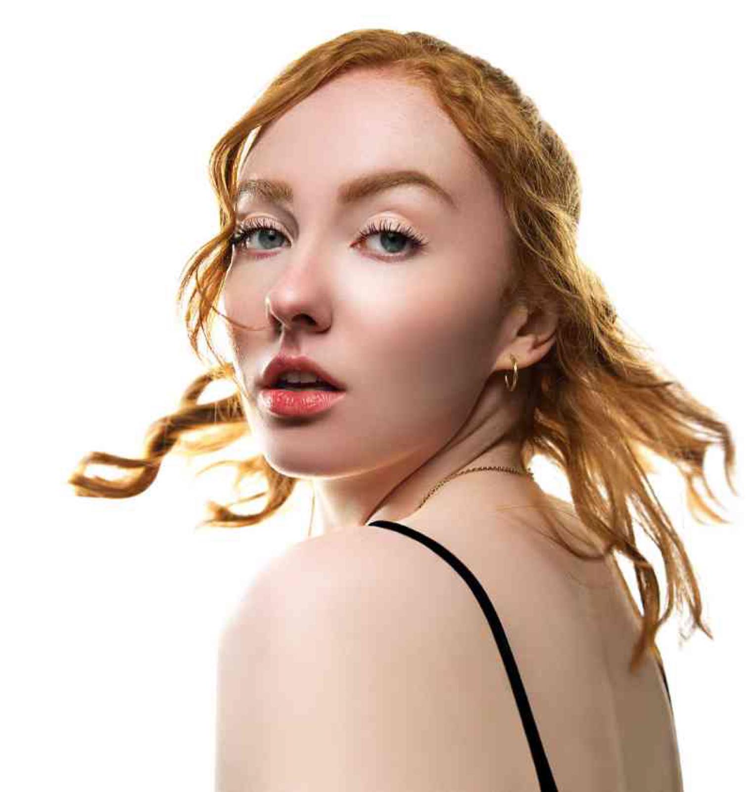 Portrait d'une femme rousse, cheveux au vent sur fond blanc