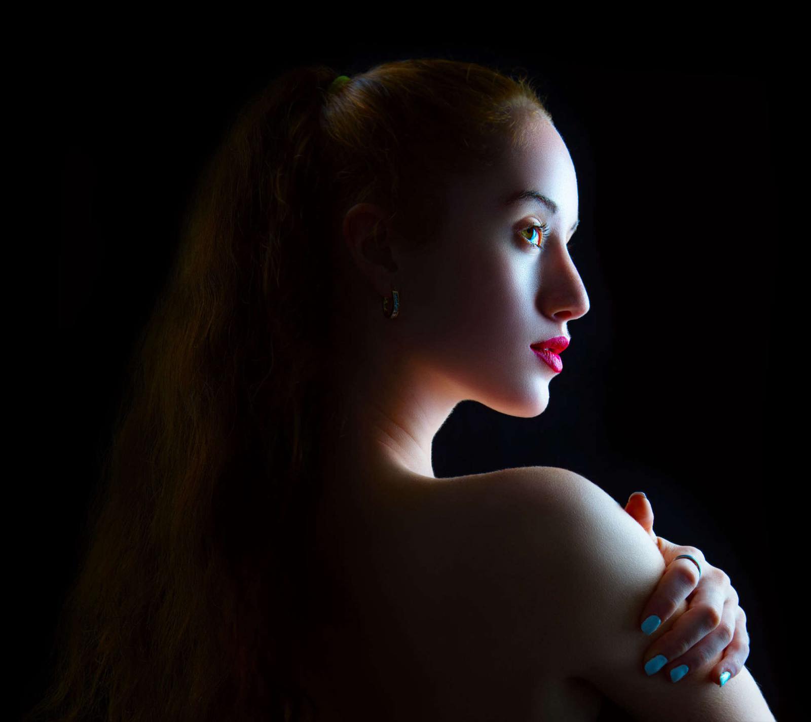 Portrait en clair-obscur sur fond noir, épaule et profil