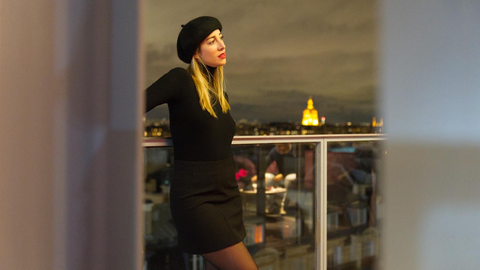 Portrait d'une femme sur un balcon parisien en fin de journée